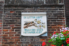 904758 Afbeelding van de gevelsteen De letter leeft waar Den Daas het papier kust boven het poortje tussen de panden ...